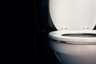 A white toilet with the lid open, shown on a black background